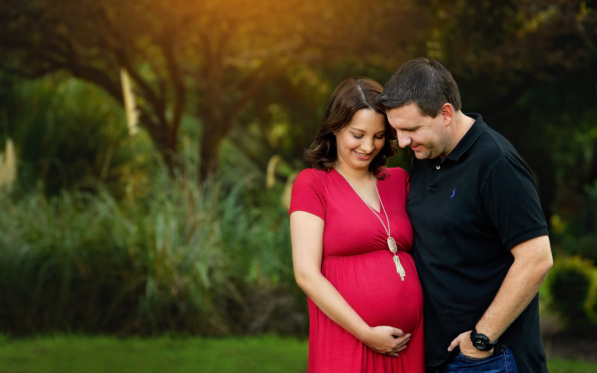 Parents-to-be admiring their baby bump for maternity photography - Natalie Roberson Photography